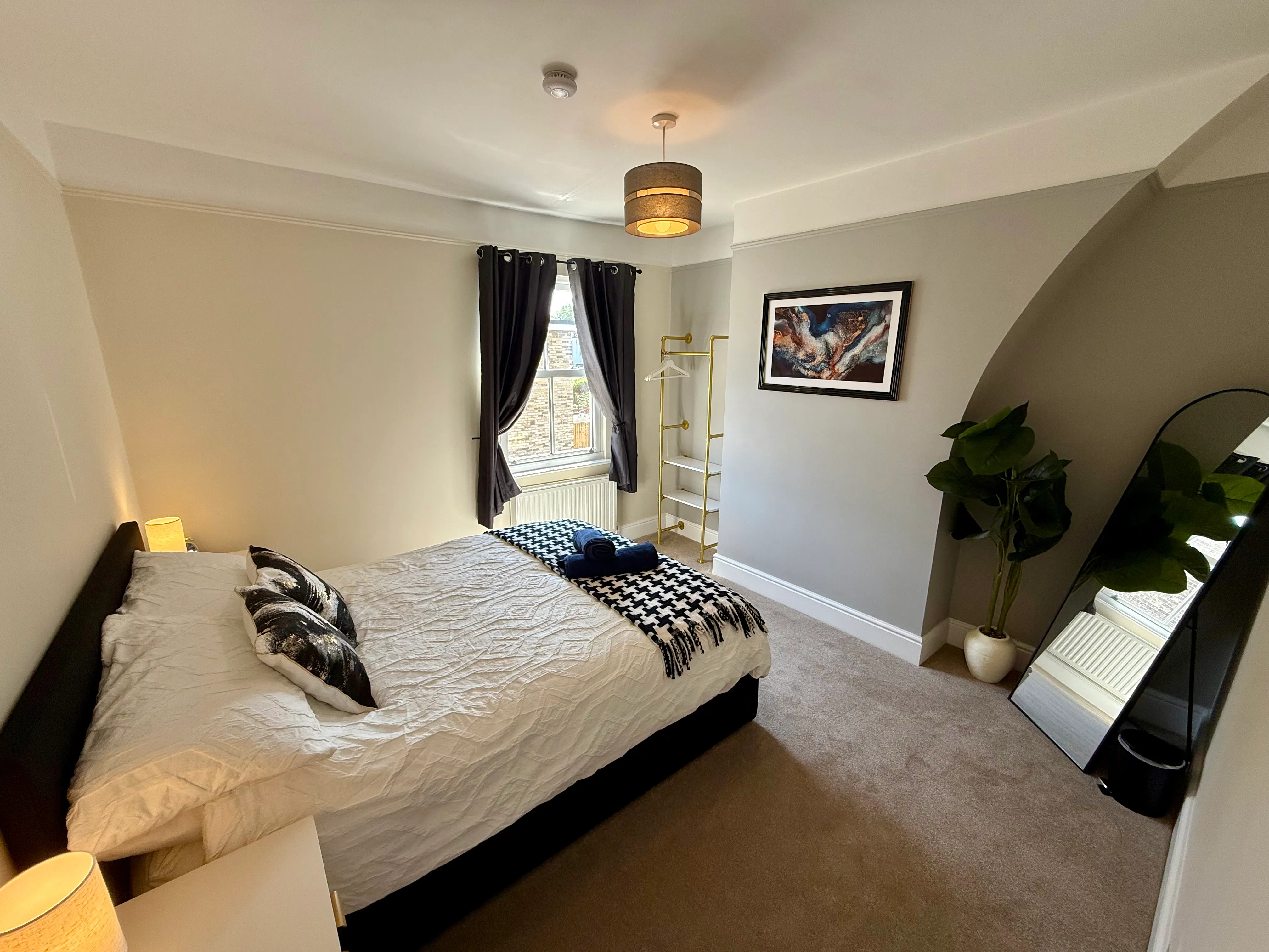 The king bedroom with monochrome bedding and gold clothes rail